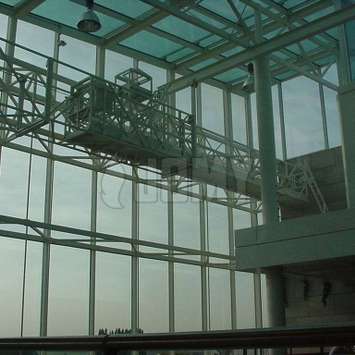 Horizontale hangbrug met een horizontale telescopische uitbreiding voor de onderhoud van een glazen dak. Horizontale hangbrug met een horizontale telescopische uitbreiding - Building Maintenance Unit